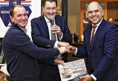 Voorzitter Tim van Zeben en Zeehaven-directeur Peter van de Meerakker overhandigen het eerste boek Noordzeevis uit IJmuiden aan wethouder Jeroen Verwoort (rechts)